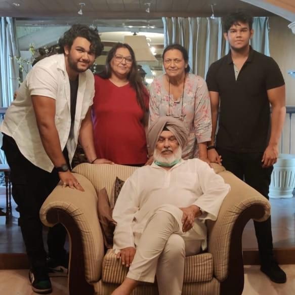 A family gathered around an elder seated in an armchair